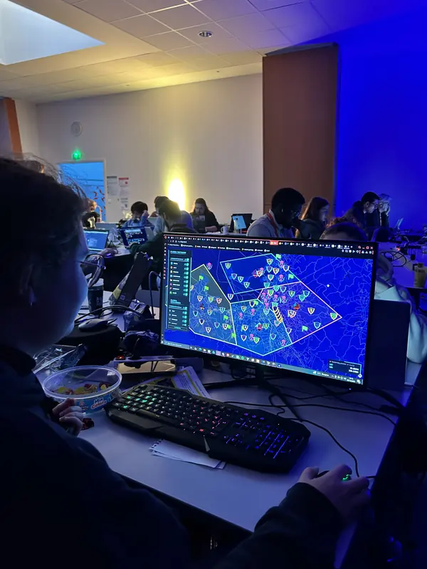Un participant du Flag'Malo 2025 devant son écran, dans une salle éclairée en bleu