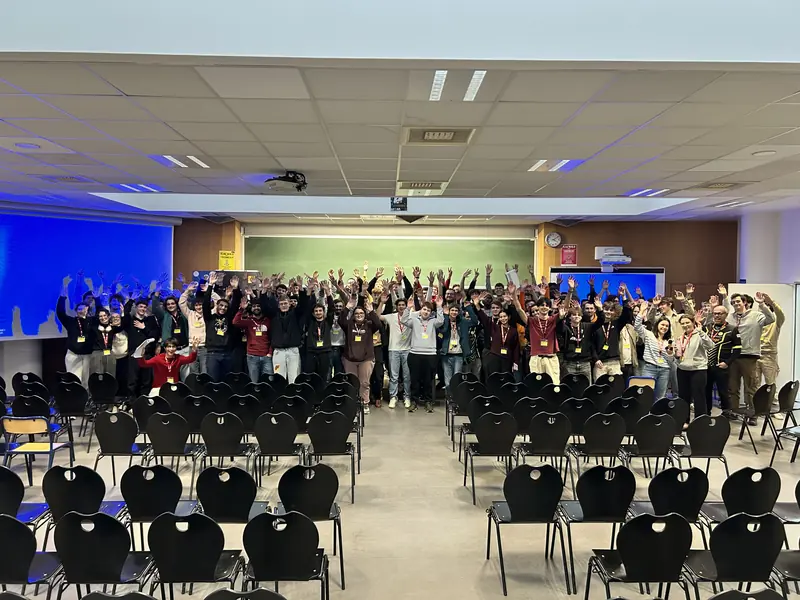 Photo de groupe des participants du Flag'Malo 2025, bras levés dans l'amphithéâtre